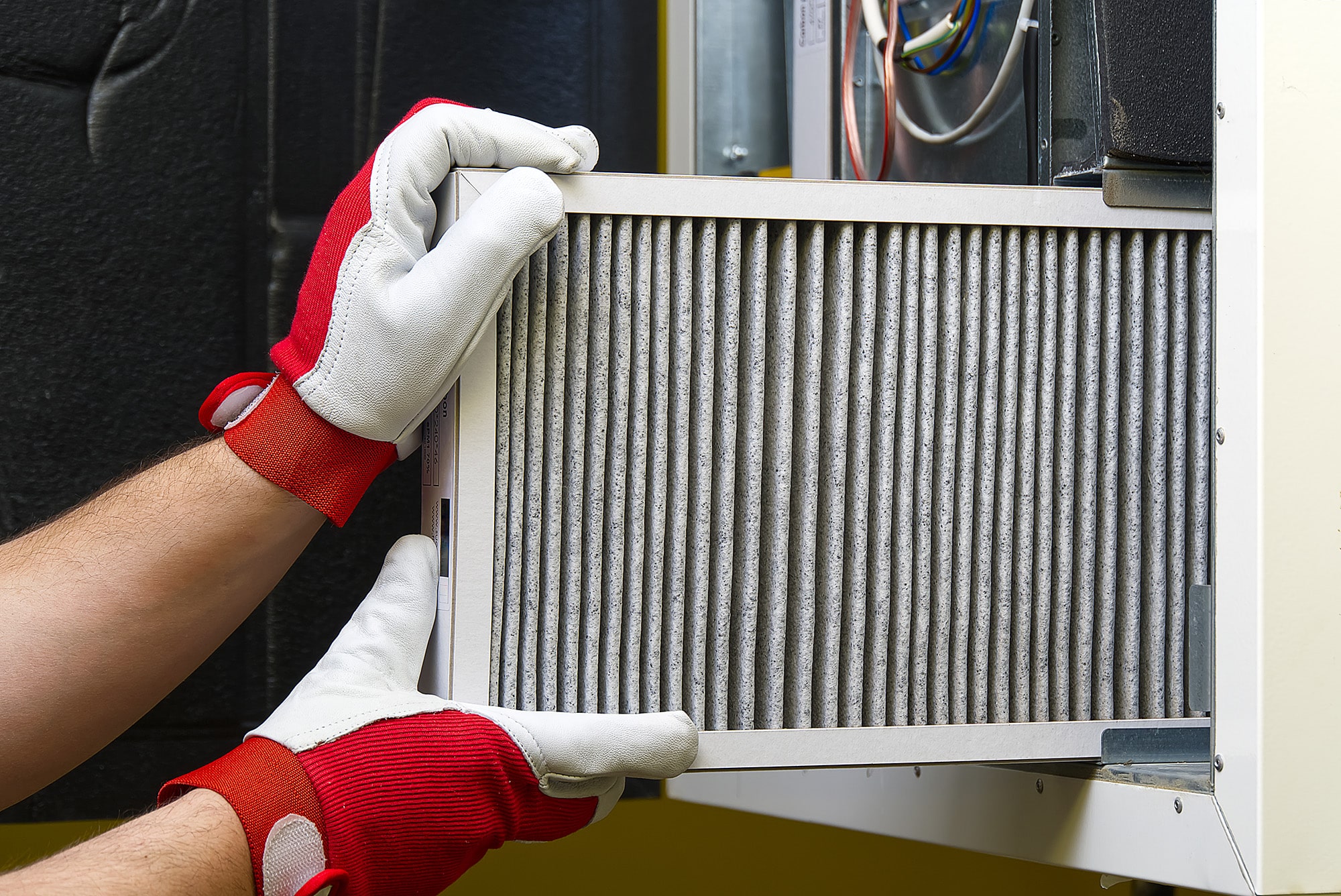 A HVAC technician checking the furnace filter during a furnace maintenance or furnace repair or service.