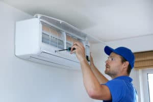 worker repairs HVAC system