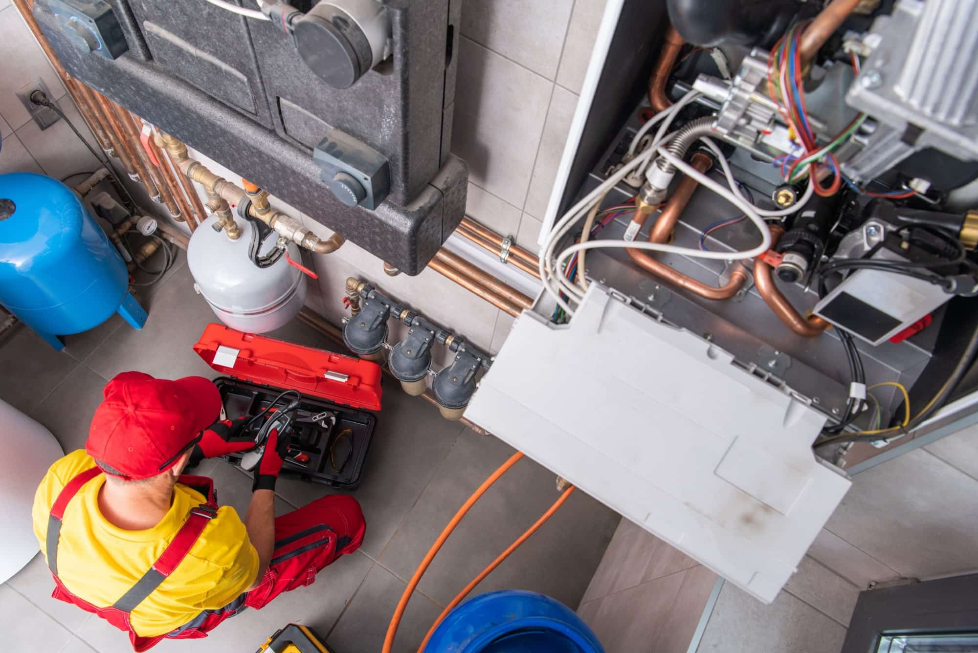 Service Plus Heating and Cooling Technician Performing Scheduled Maintenance on the Gas Heating System for Property Manager