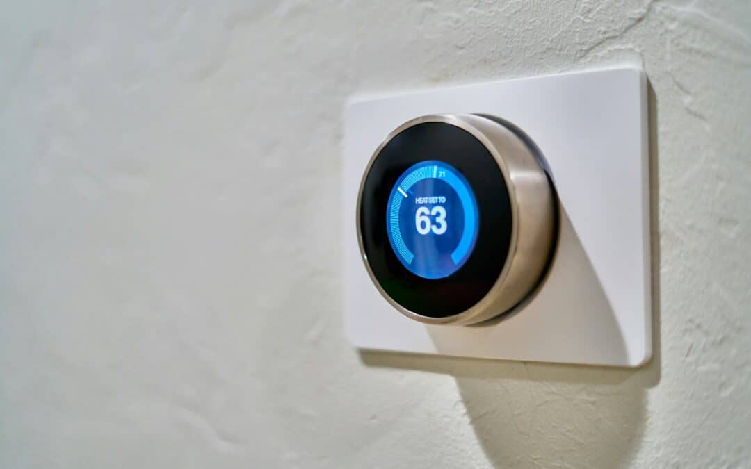 Smart thermostat mounted on wall with blue digital display